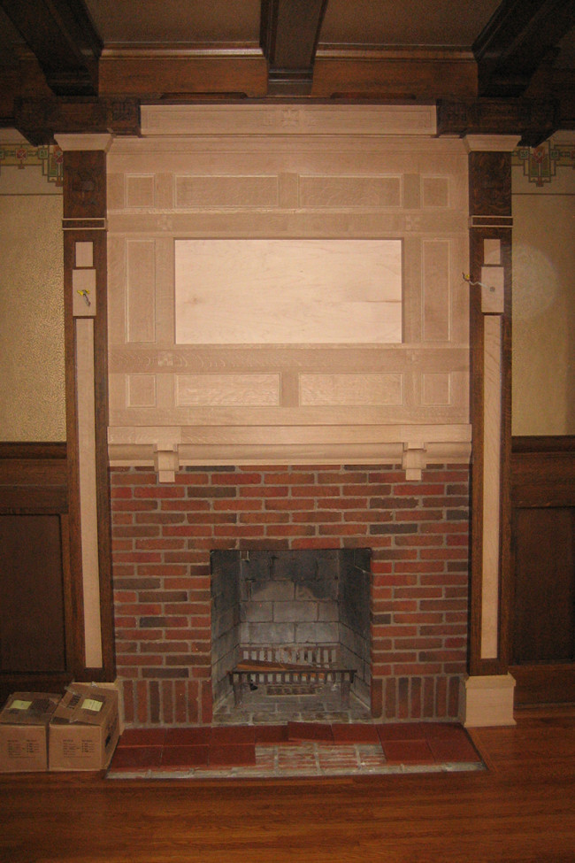Step 6 A new coffered white oak chimney breast and mantel have been installed, and other details of the wood trim that had been damaged or removed have been replaced. A new terra cotta tile hearth is being laid.